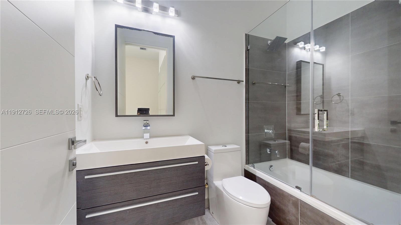 3461 Southwest 25th Street, Unit A Miami, FL 33133 - Photo 21 of 27 a bathroom with a sink a toilet and shower