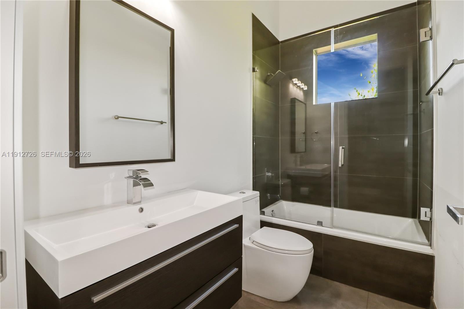 3461 Southwest 25th Street, Unit A Miami, FL 33133 - Photo 23 of 27 a bathroom with a sink and a mirror