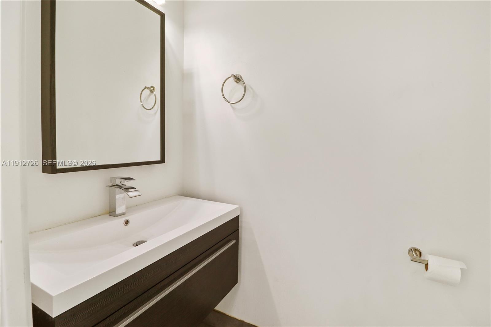 3461 Southwest 25th Street, Unit A Miami, FL 33133 - Photo 24 of 27 a bathroom with a sink and a mirror