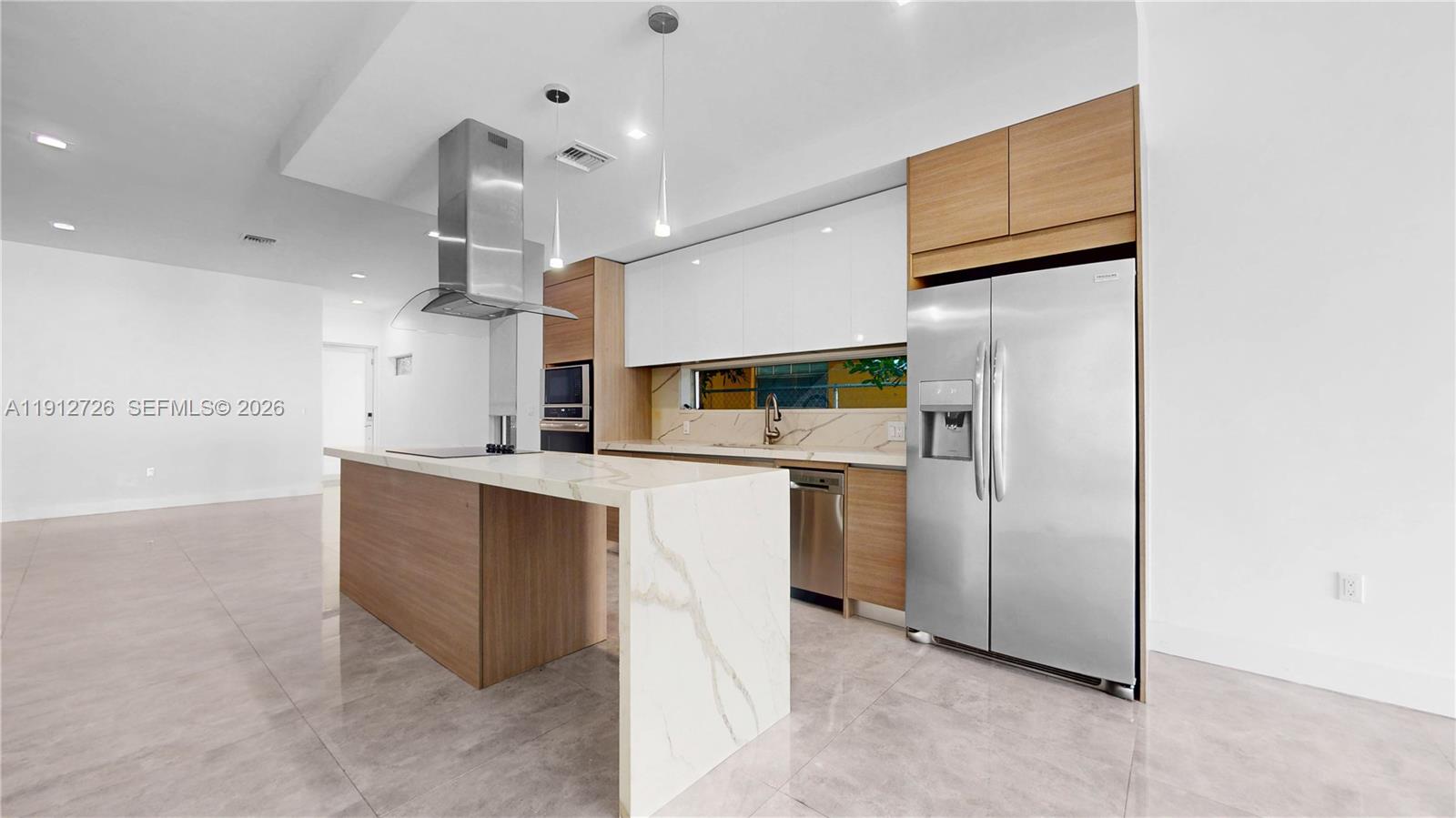 3461 Southwest 25th Street, Unit A Miami, FL 33133 - Photo 3 of 27 a kitchen with stainless steel appliances a refrigerator and a sink