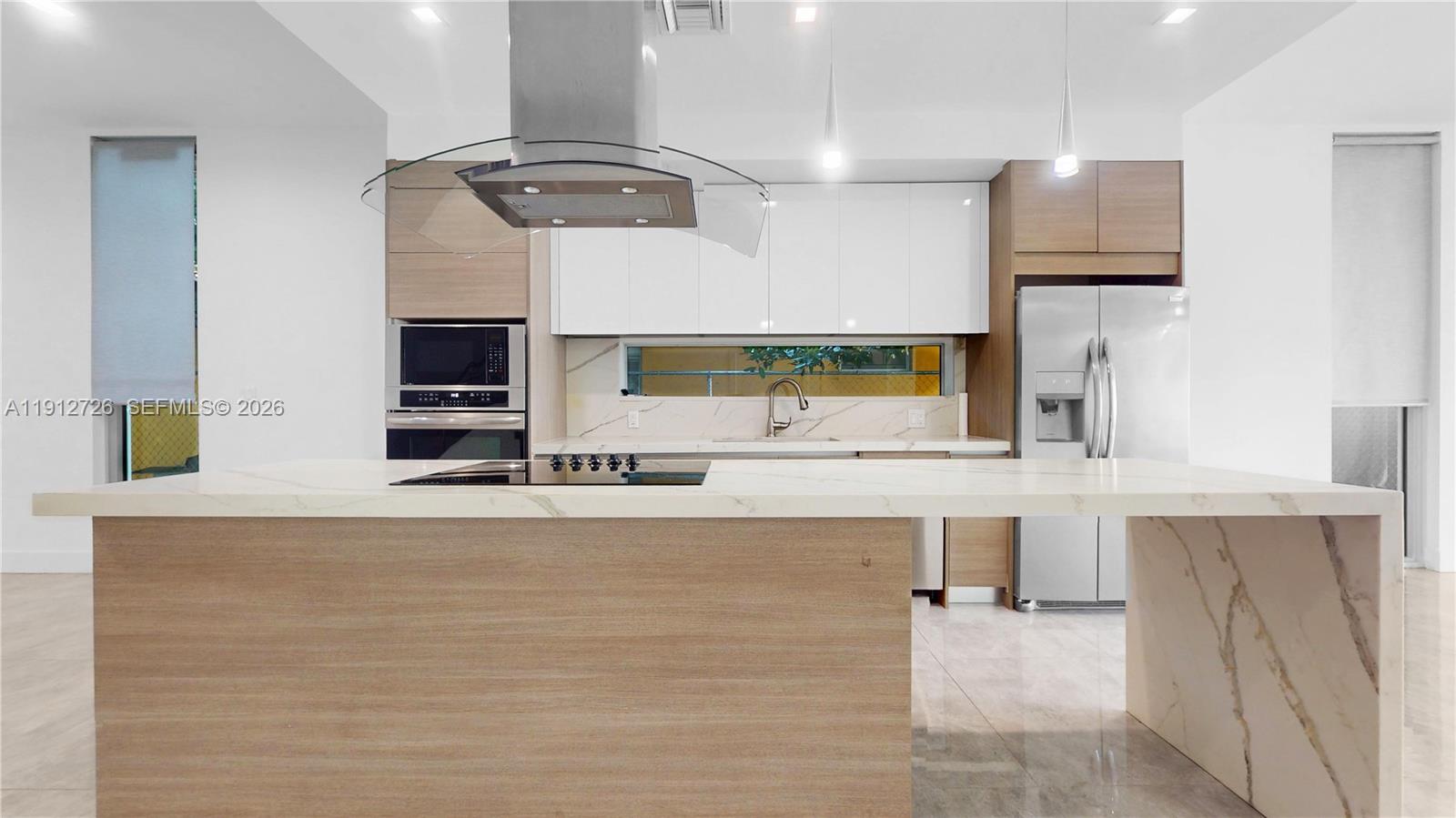 3461 Southwest 25th Street, Unit A Miami, FL 33133 - Photo 4 of 27 a kitchen with stainless steel appliances a sink and a microwave