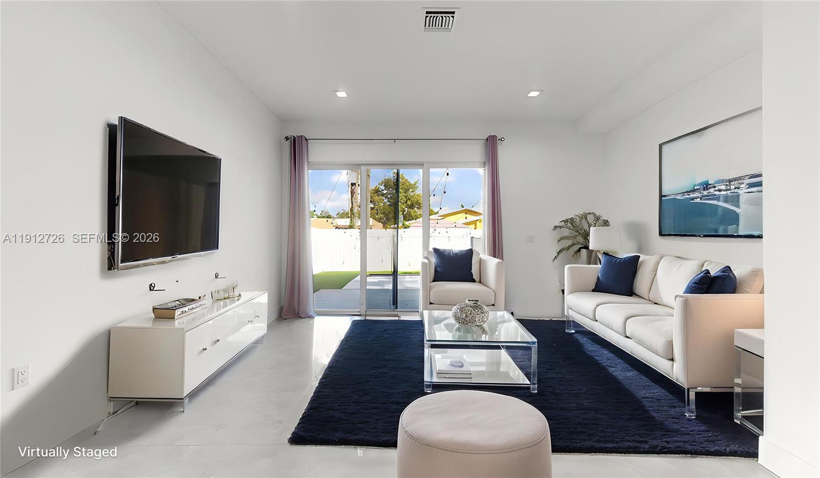 3461 Southwest 25th Street, Unit A Miami, FL 33133 - Photo 8 of 27 a living room with furniture and a flat screen tv
