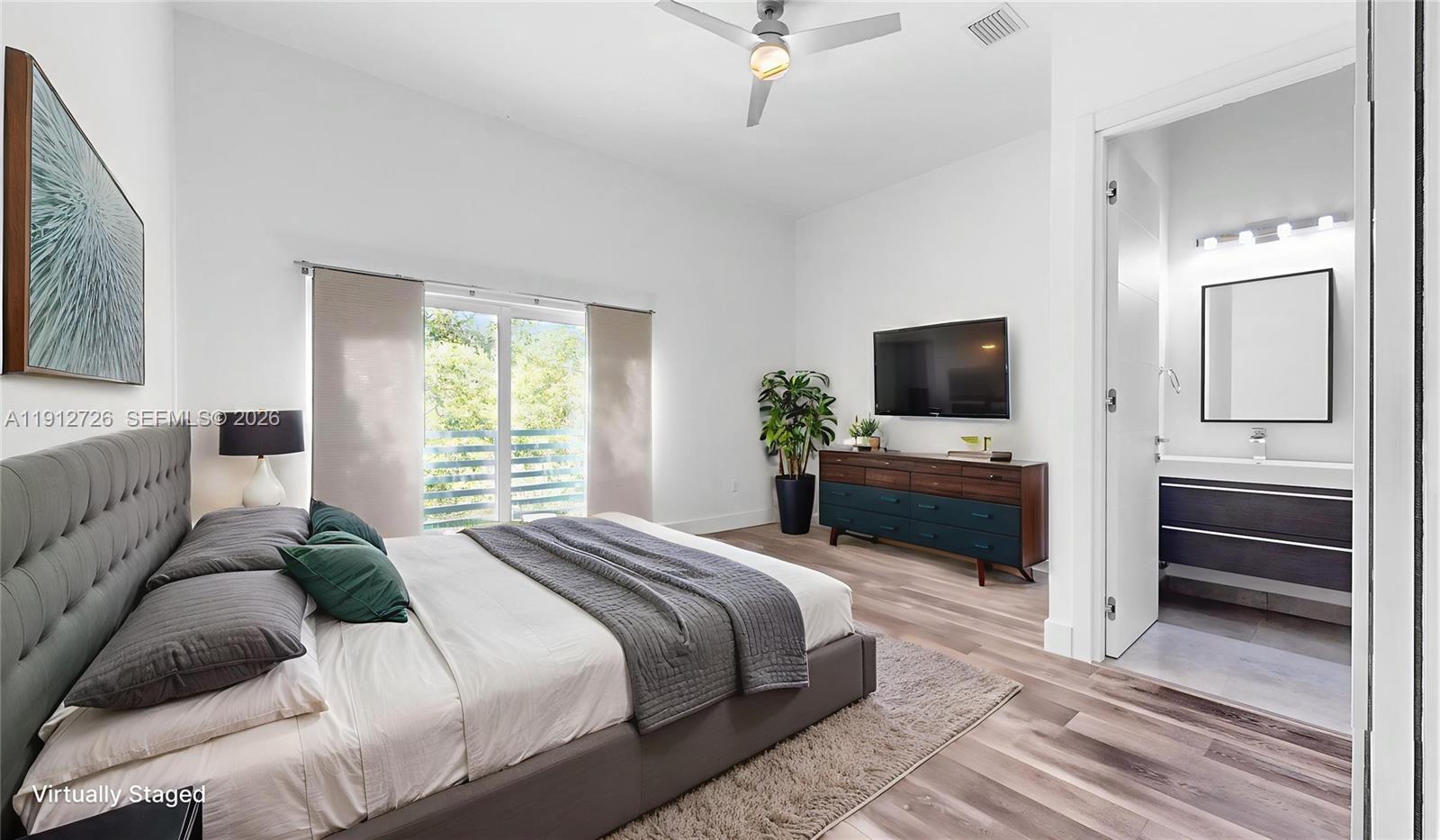 3461 Southwest 25th Street, Unit A Miami, FL 33133 - Photo 10 of 27 a bedroom with a bed and a flat screen tv