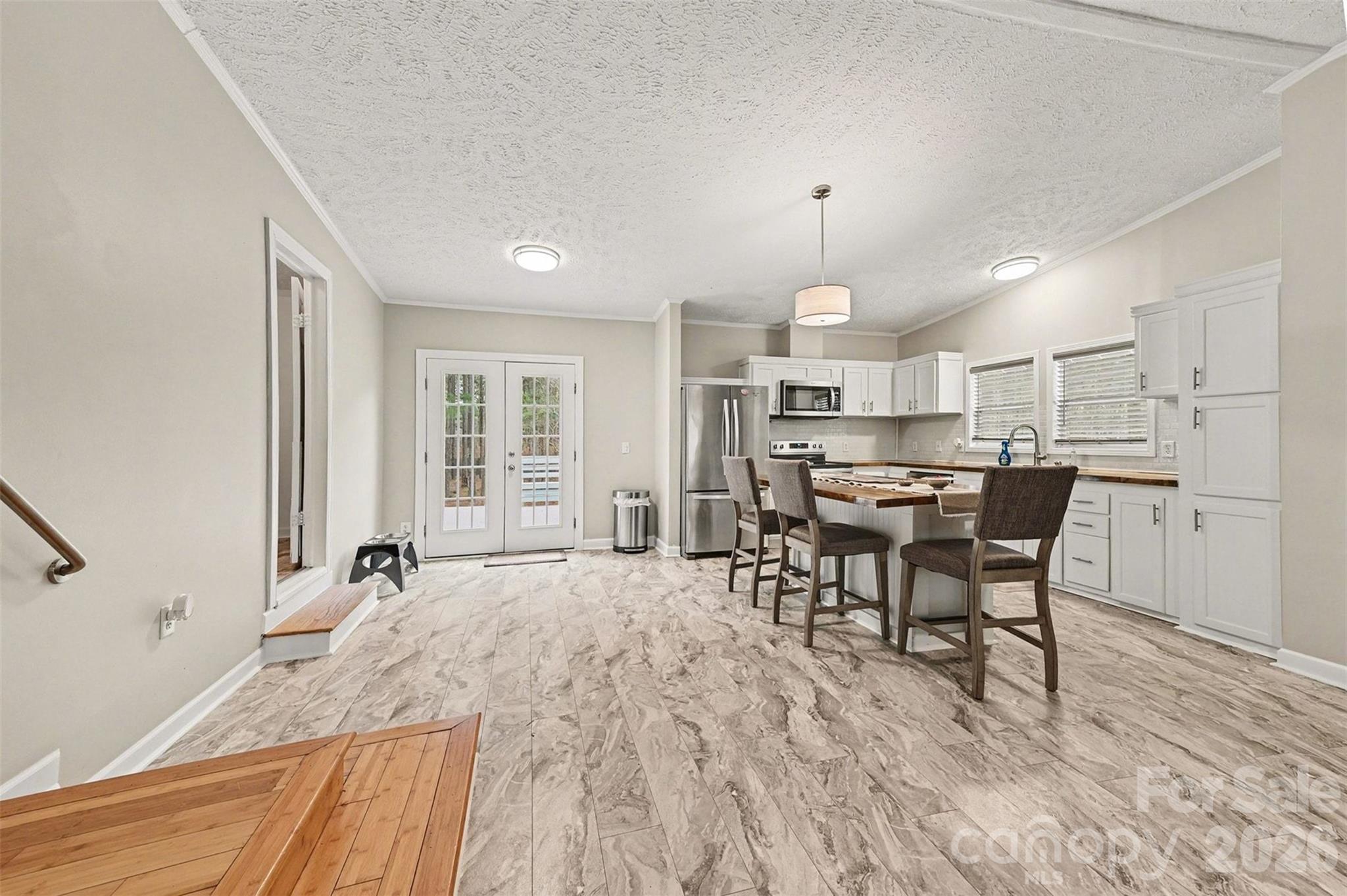 5018 Duncan Road Monroe, NC 28110 - Photo 12 of 33 a open kitchen with stainless steel appliances granite countertop a stove top oven a sink dishwasher a dining table and chairs with wooden floor