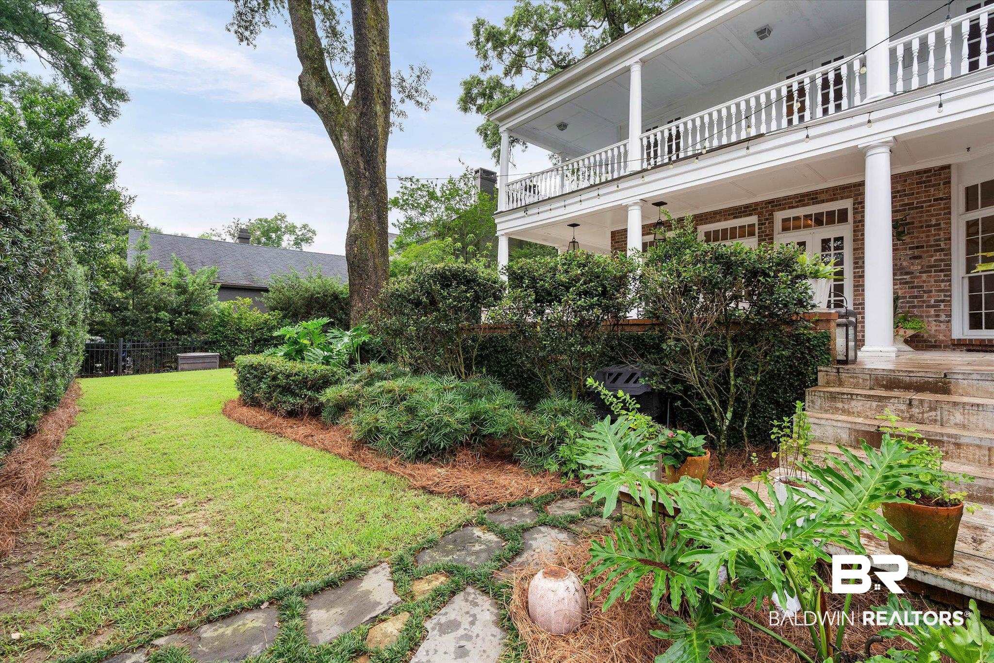 3908 Yester Place Mobile, AL 36608 - Photo 35 of 45 Expansive backyard with a manicured lawn, established garden beds, and mature trees