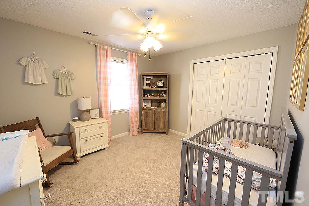 5029 Denham Court Raleigh, NC 27613 - Photo 9 of 13 a bedroom with furniture and a chandelier