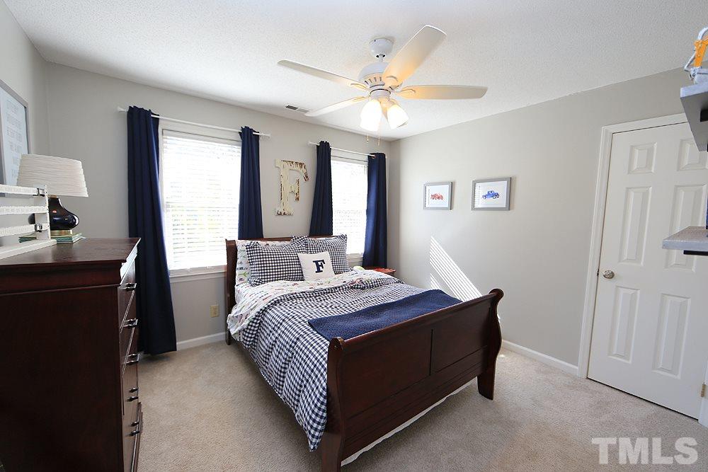 5029 Denham Court Raleigh, NC 27613 - Photo 10 of 13 a bedroom with a bed and a chandelier