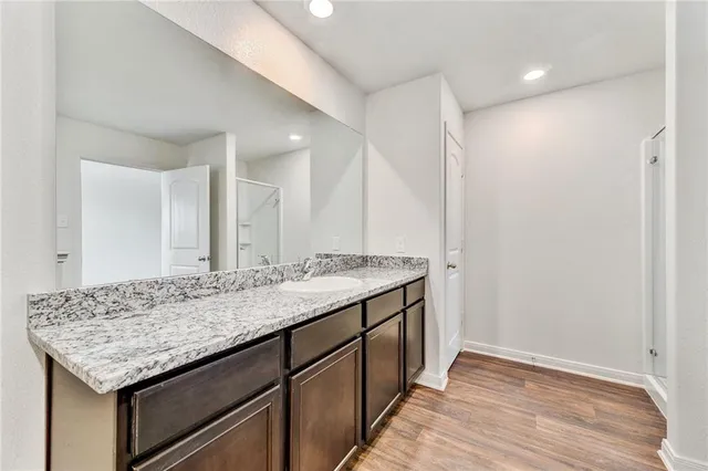 a bathroom with a granite countertop sink and a mirror