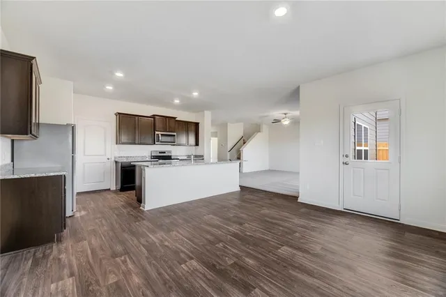 a view of kitchen with granite countertop cabinets and refrigerator