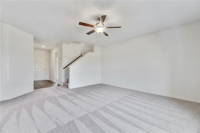 an empty room with a ceiling fan and wooden floor