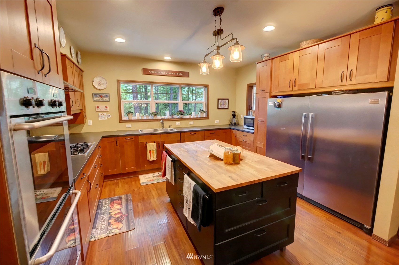 17 Highland Road Winthrop, WA 98862 - Photo 7 of 40 a kitchen with stainless steel appliances granite countertop a refrigerator a stove and a sink with wooden floor