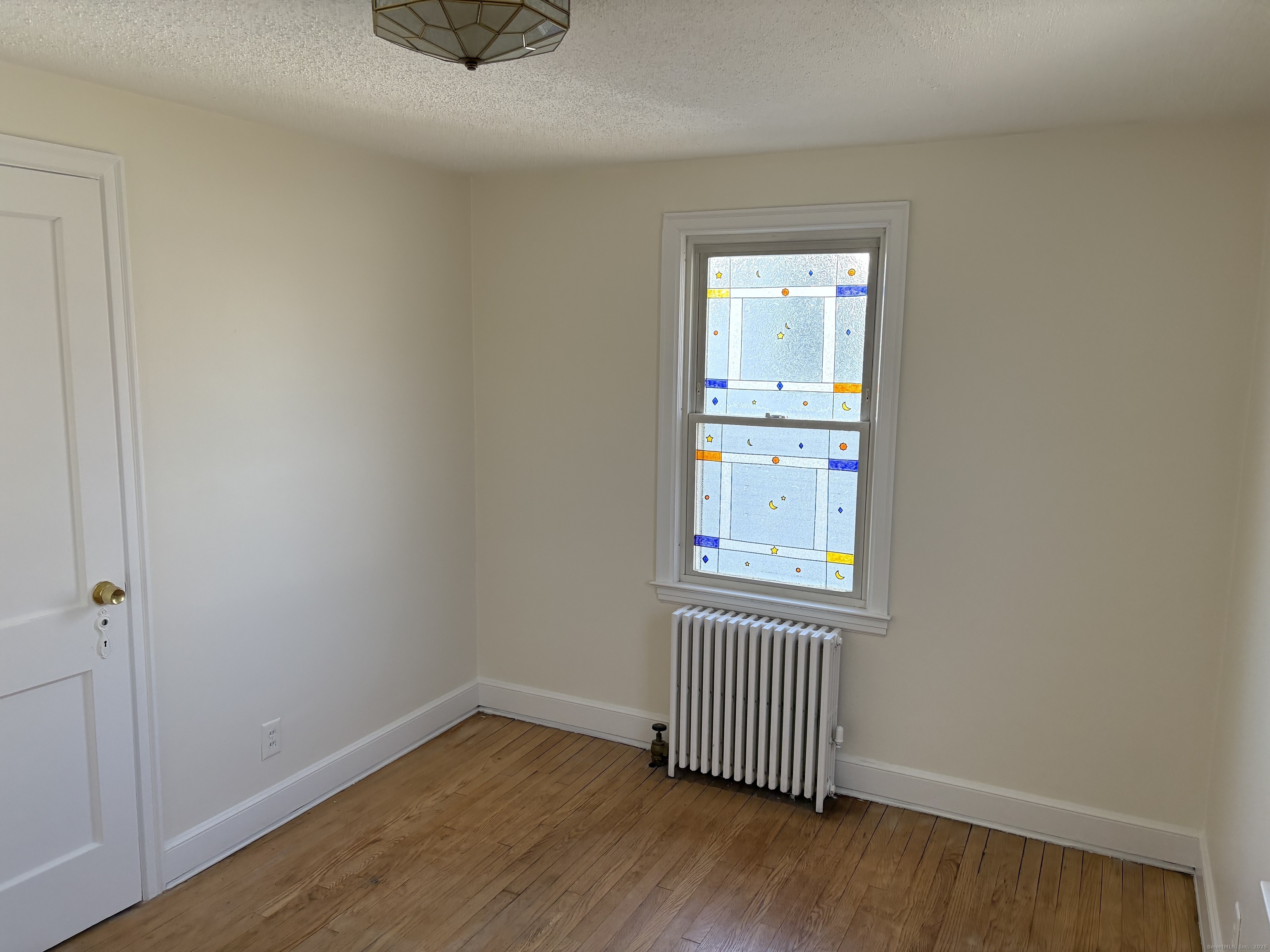 85 Benton Street Manchester, CT 06040 - Photo 11 of 34 an empty room with wooden floor and windows