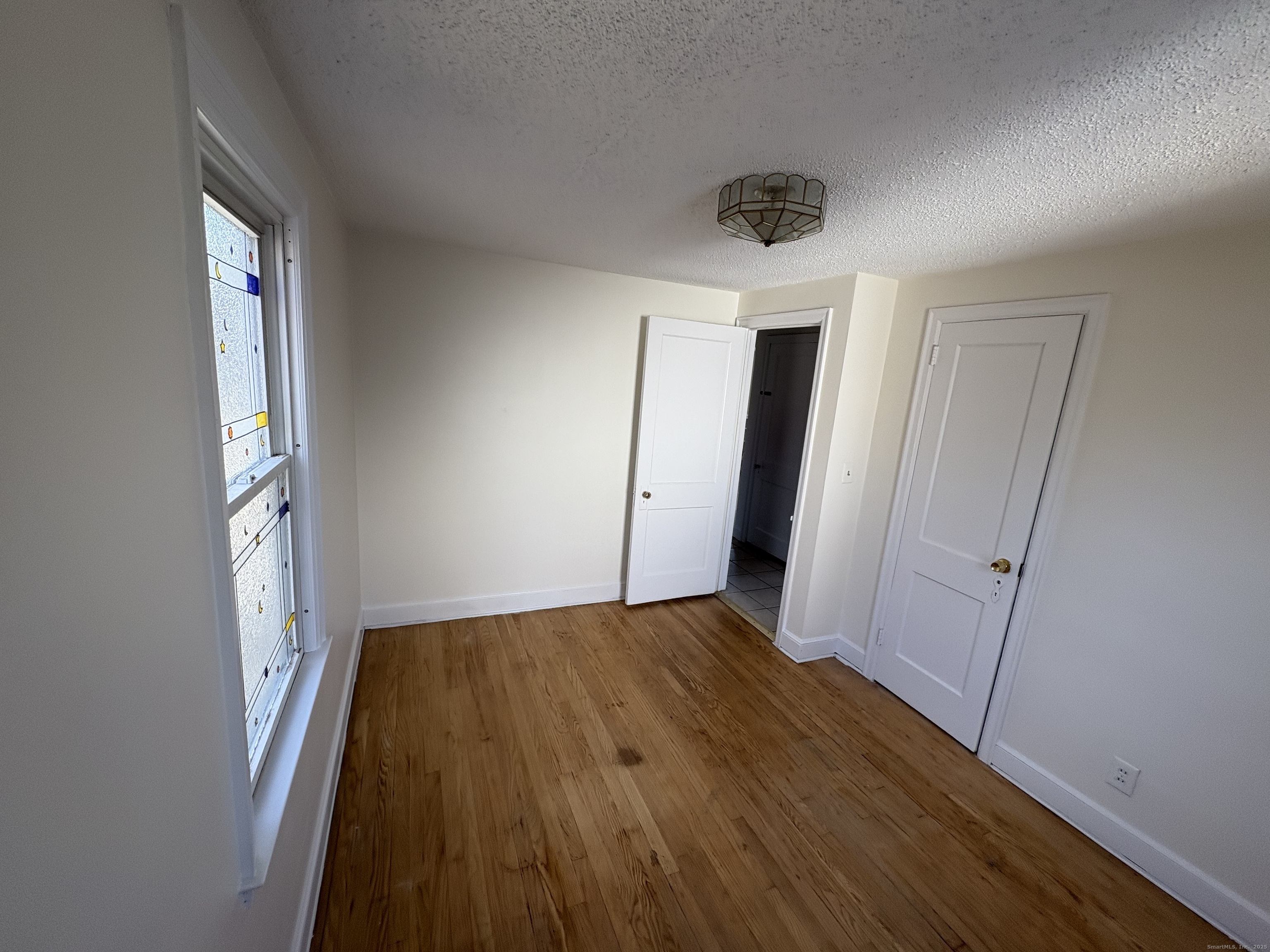 85 Benton Street Manchester, CT 06040 - Photo 14 of 34 wooden floor in an empty room with a window