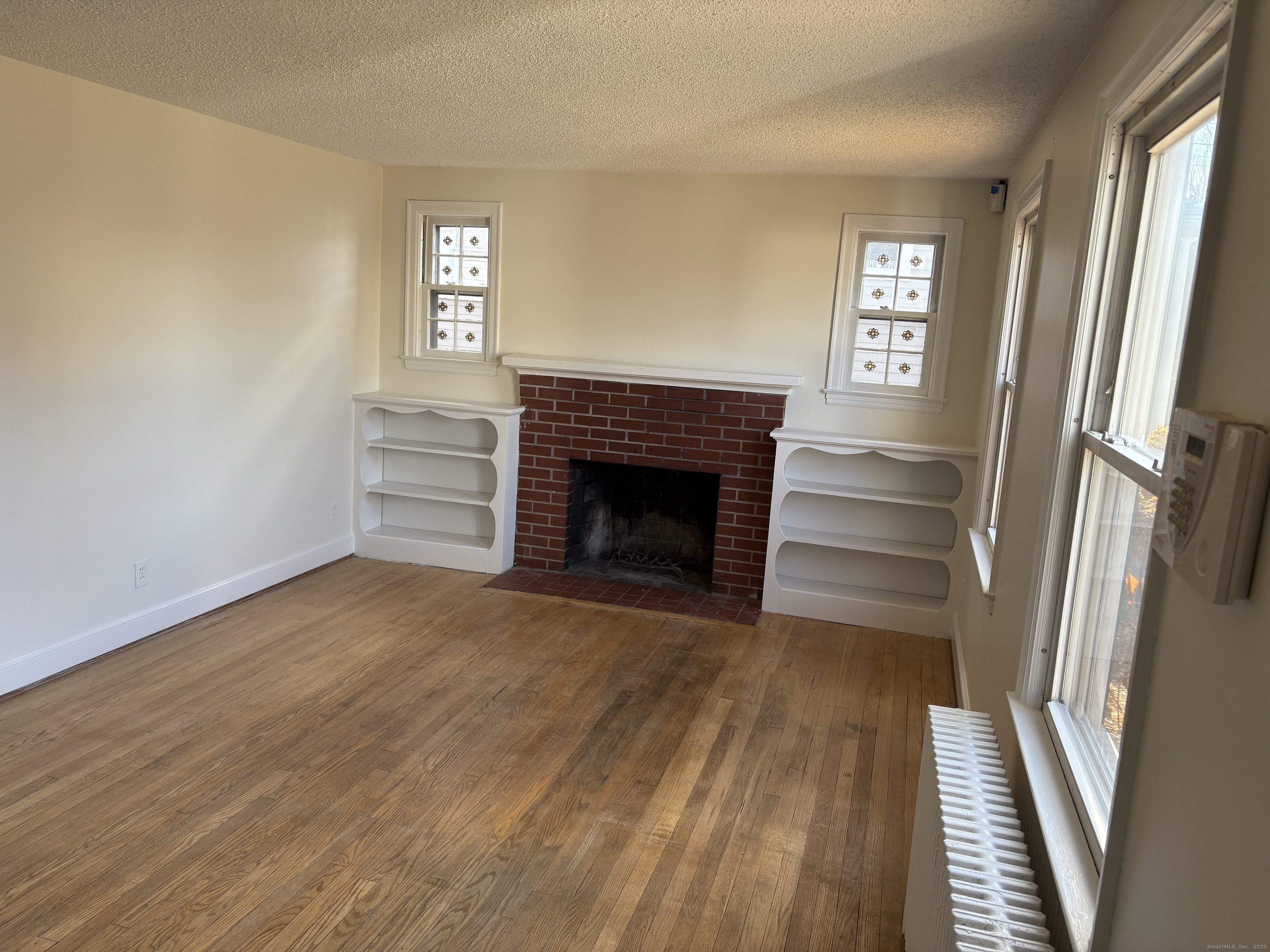 85 Benton Street Manchester, CT 06040 - Photo 3 of 34 a view of a livingroom with wooden floor and a fireplace