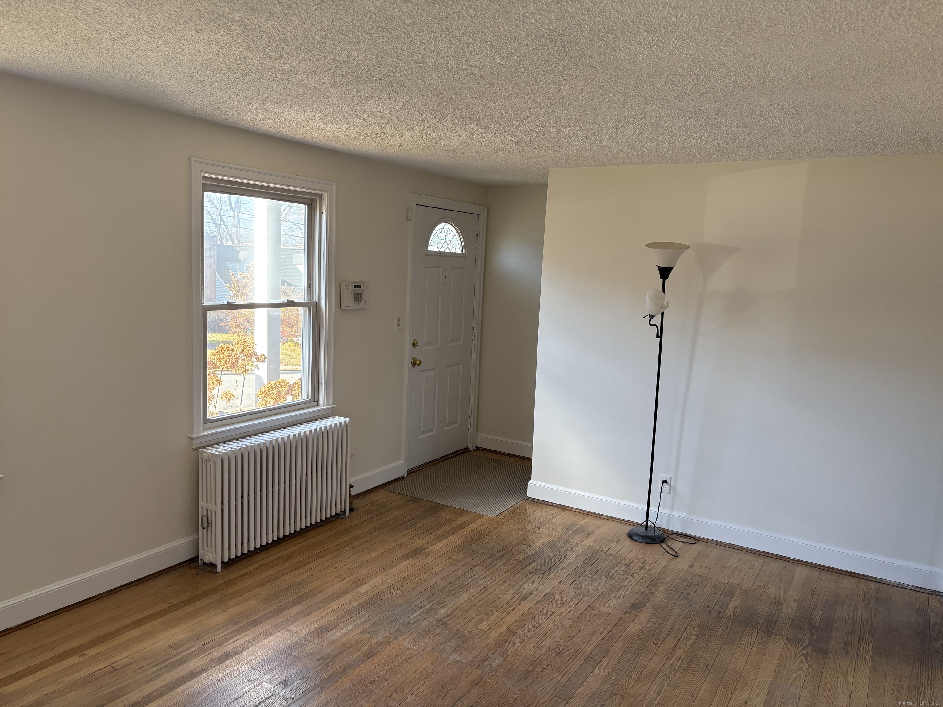 85 Benton Street Manchester, CT 06040 - Photo 5 of 34 a view of an empty room with window and wooden floor