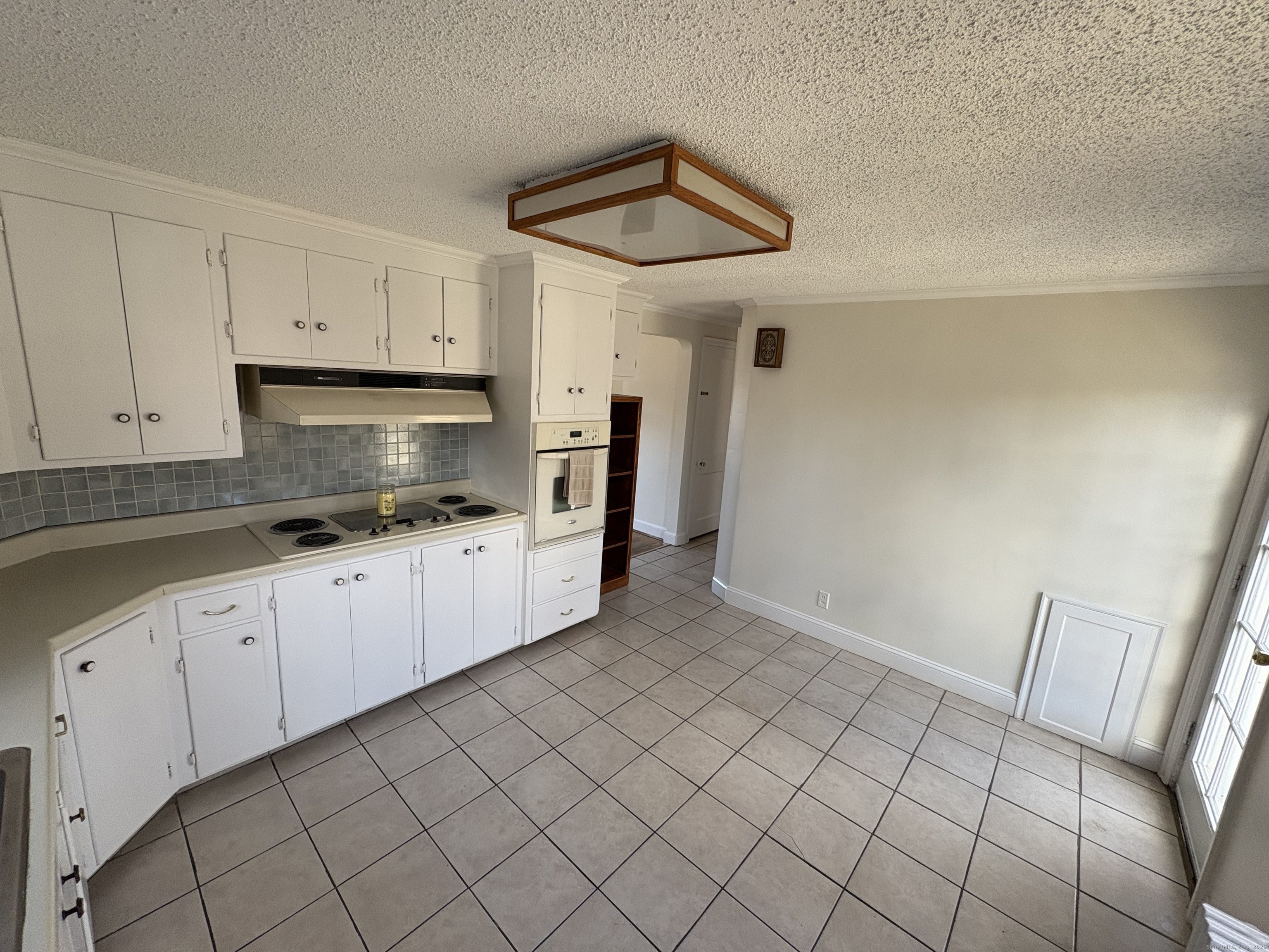 85 Benton Street Manchester, CT 06040 - Photo 8 of 34 a kitchen with white cabinets a sink dishwasher and a stove with wooden floor