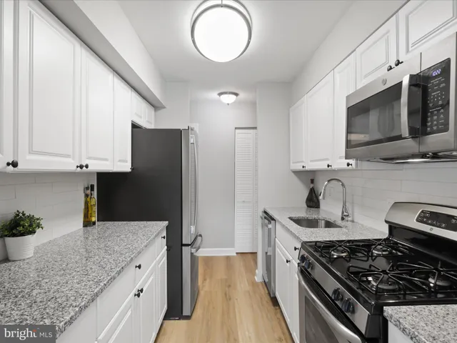 a kitchen with stainless steel appliances granite countertop a stove a sink dishwasher and a refrigerator