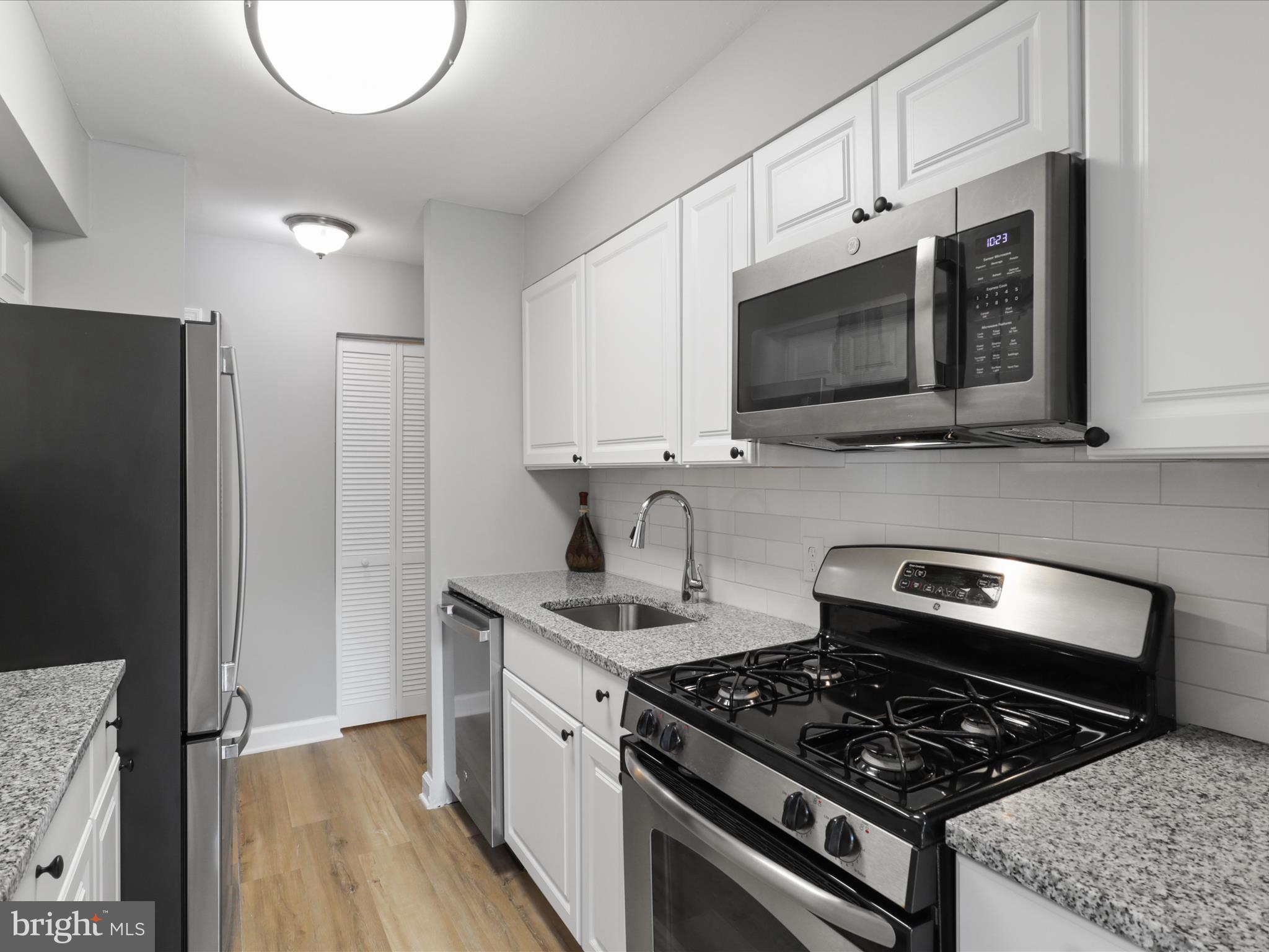 8316 Tobin Road, Unit 831611 Annandale, VA 22003 - Photo 14 of 41 a kitchen with stainless steel appliances granite countertop a stove a microwave and a refrigerator