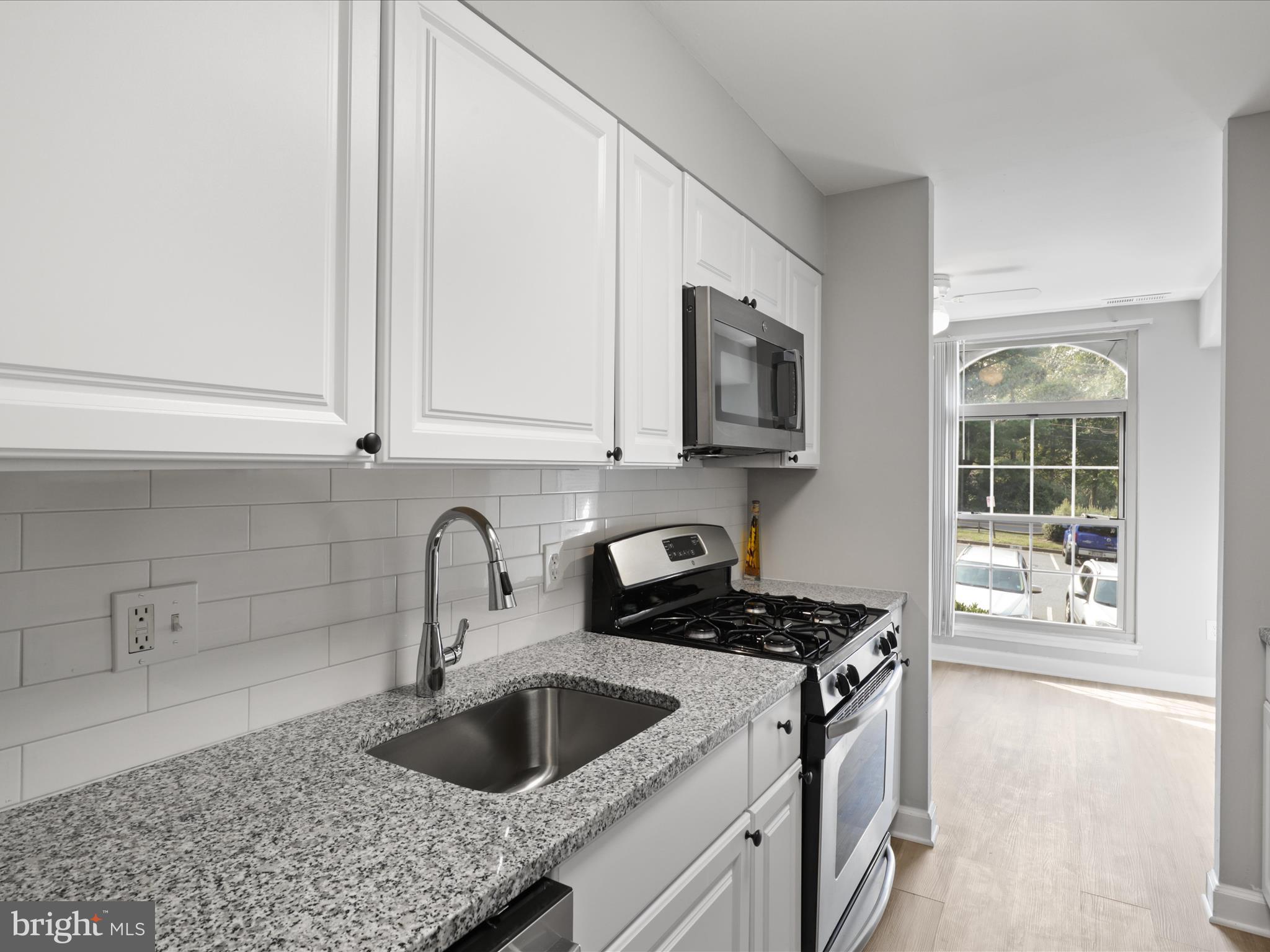 8316 Tobin Road, Unit 831611 Annandale, VA 22003 - Photo 15 of 41 a kitchen with stainless steel appliances granite countertop a sink a stove and a microwave oven