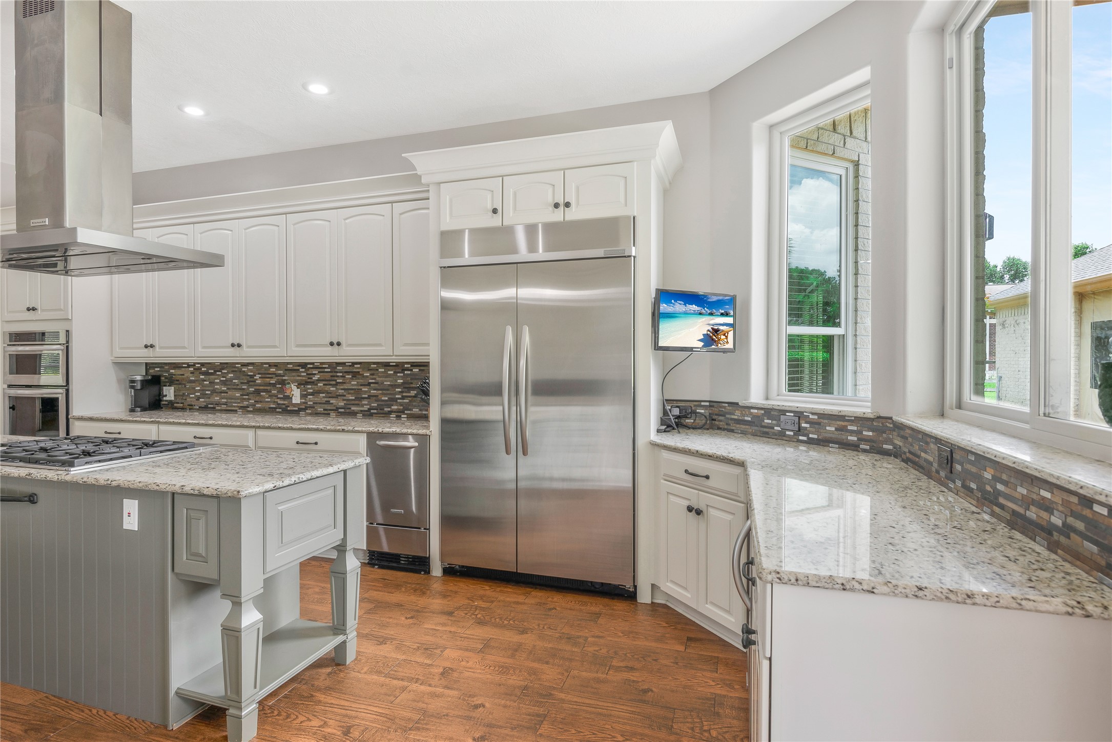 13914 Skinner Road Cypress, TX 77429 - Photo 12 of 50 Updated kitchen with plenty of cabinet space, granite countertops, stainless steel appliances, a center island, and large windows overlooking the backyard.