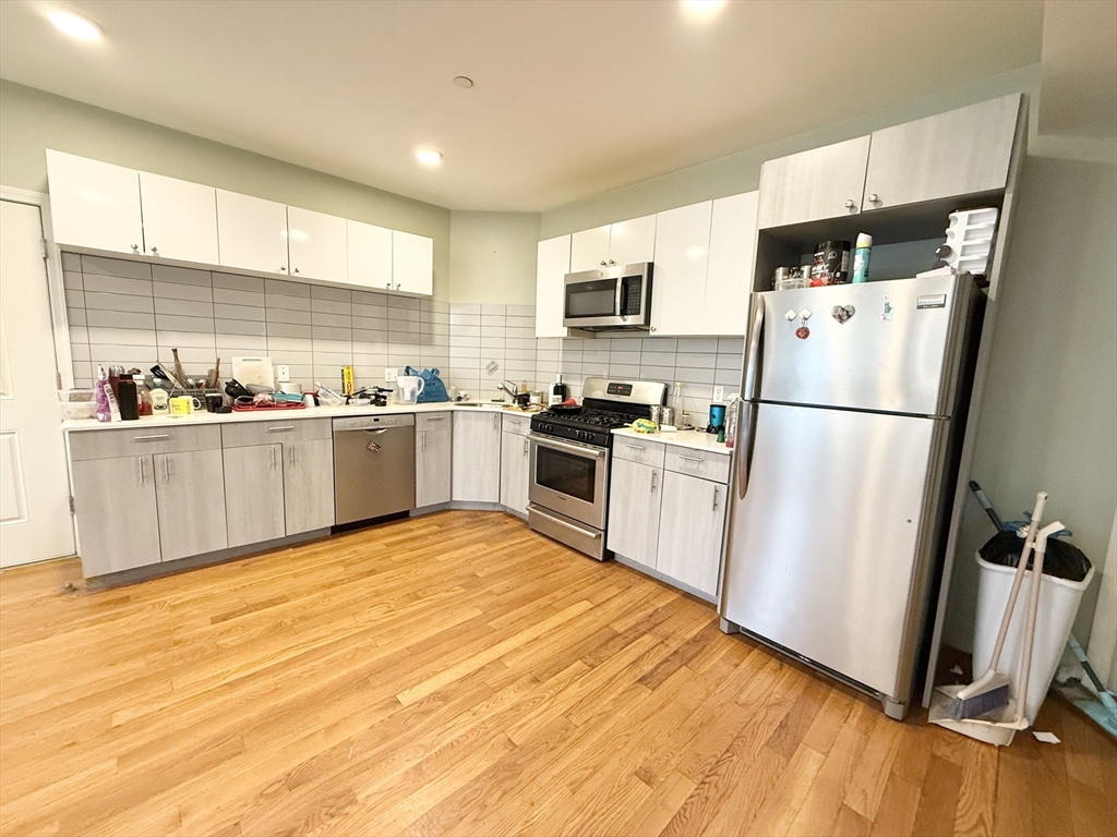 a kitchen with granite countertop stainless steel appliances a refrigerator a sink a stove top oven and a refrigerator