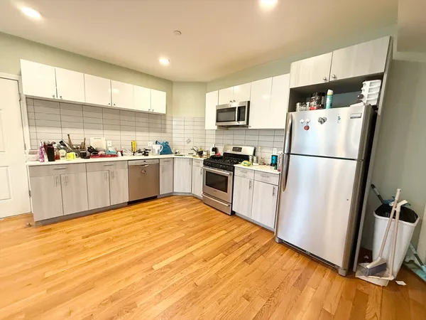 a kitchen with stainless steel appliances a refrigerator a sink a stove a microwave a sink a refrigerator and cabinets