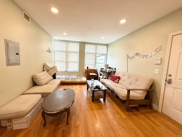 a living room with furniture and a wooden floor