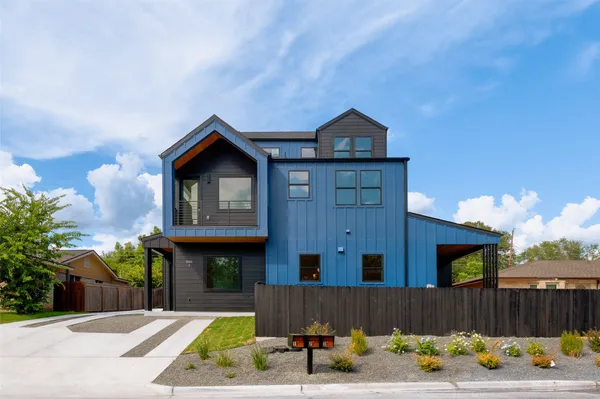 a front view of a house with a yard and seating space