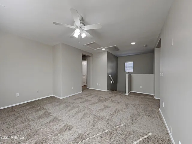 an empty room with fan and windows