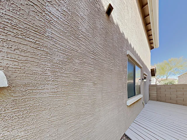 a view of a pathway with a brick wall