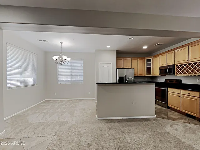a view of kitchen with kitchen island stainless steel appliances a sink counter space and a window