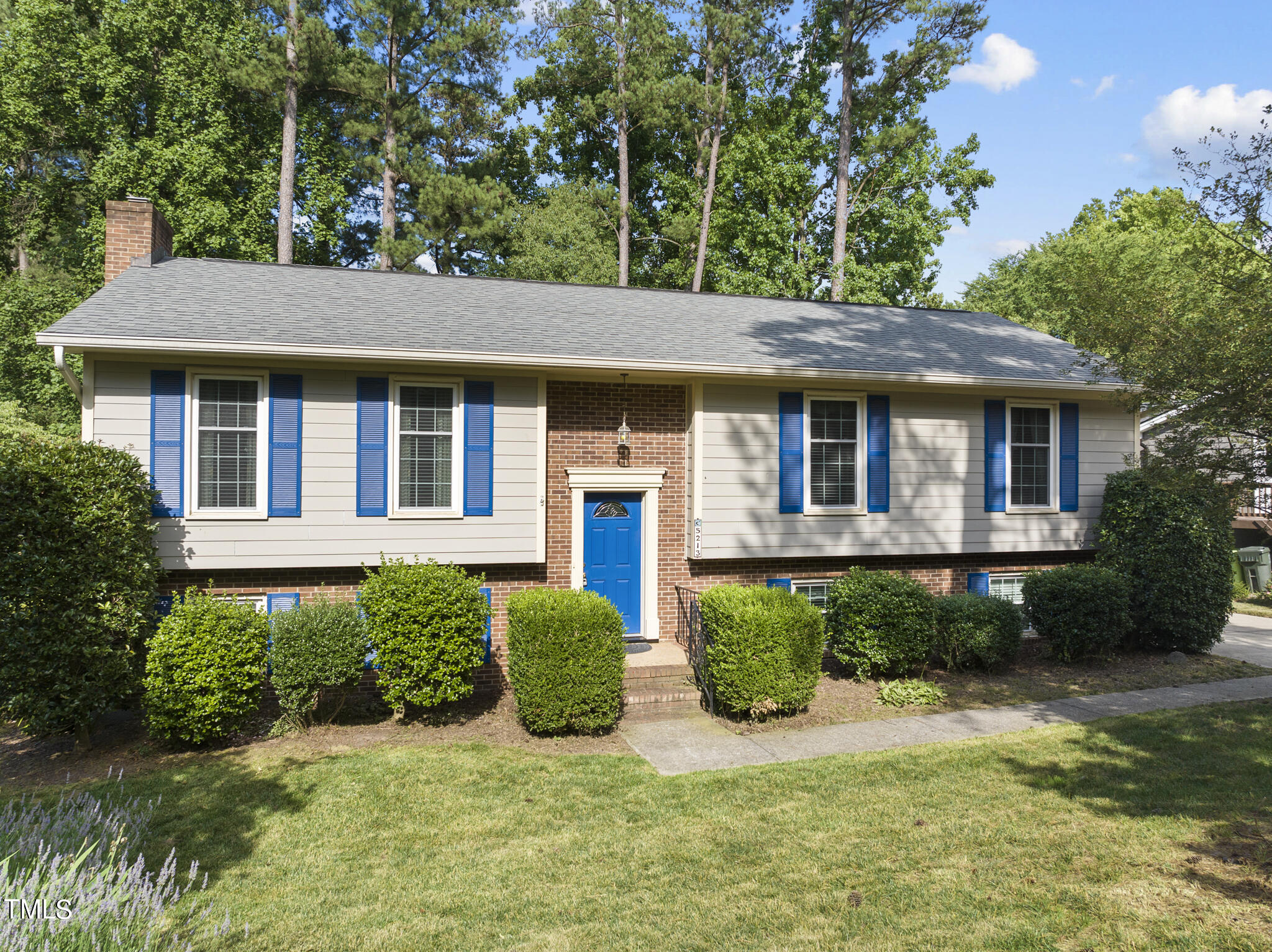 a view of a house with a yard potted plants and a table