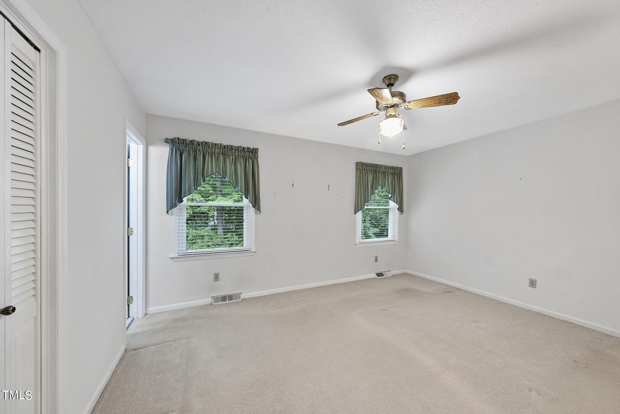 5213 Old Forge Circle Raleigh, NC 27609 - Photo 24 of 37 an empty room with a window and a ceiling fan