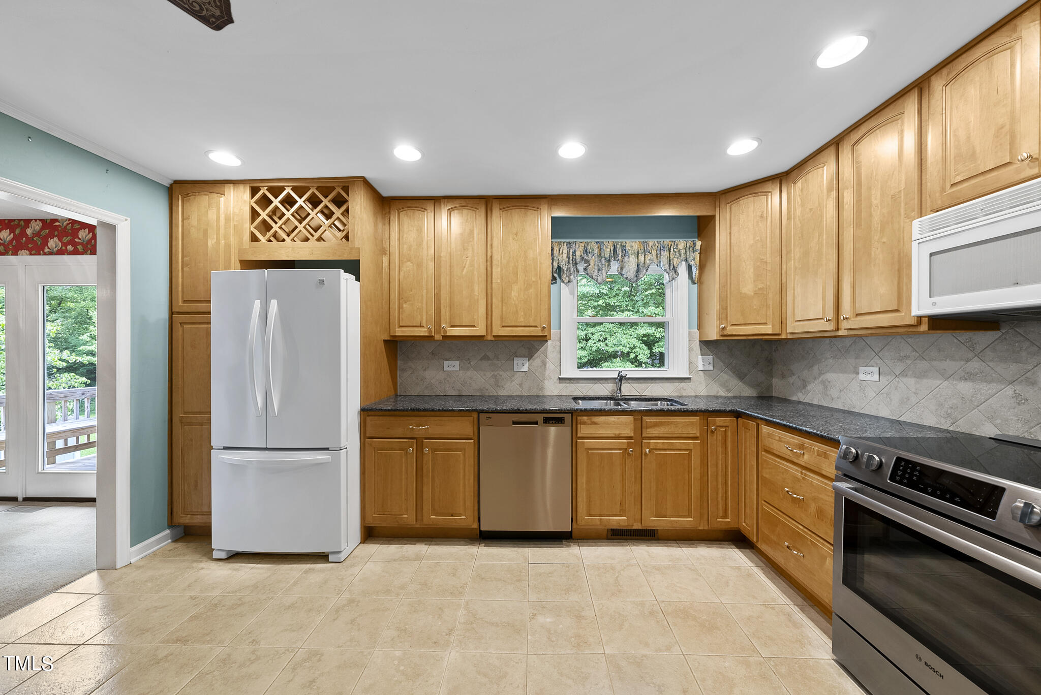 5213 Old Forge Circle Raleigh, NC 27609 - Photo 3 of 37 a kitchen with granite countertop stainless steel appliances a refrigerator sink and microwave