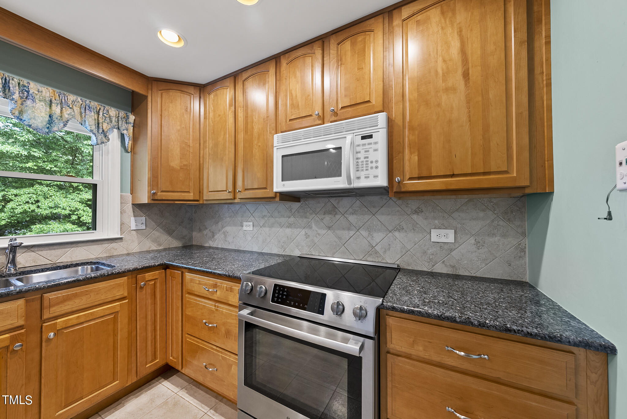 5213 Old Forge Circle Raleigh, NC 27609 - Photo 4 of 37 a kitchen with granite countertop cabinets stainless steel appliances and window
