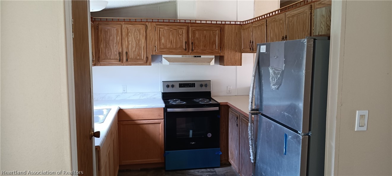 1026 Cardinal Road Wauchula, FL 33873 - Photo 4 of 12 a kitchen with stainless steel appliances granite countertop a refrigerator and a stove