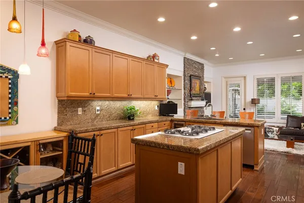 a kitchen with a stove a sink a kitchen island with a dining table and chairs