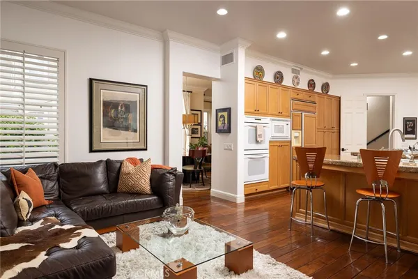 a living room with furniture wooden floor and kitchen view