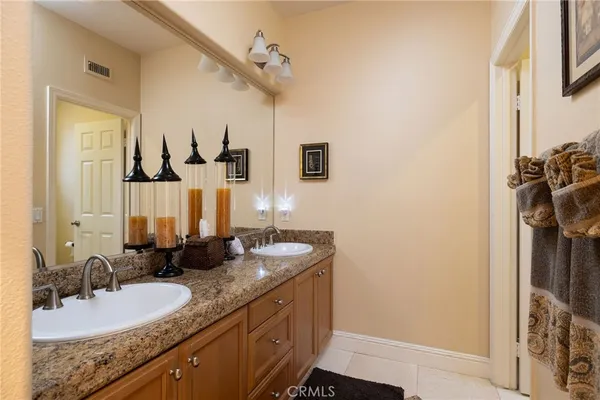 a bathroom with a granite countertop sink a mirror and shower
