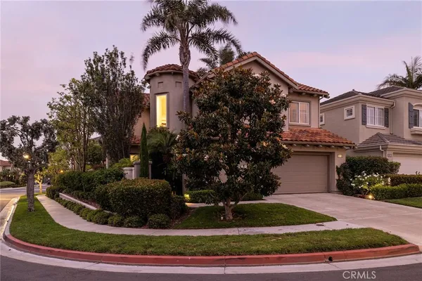 a view of a house with a yard and potted plants
