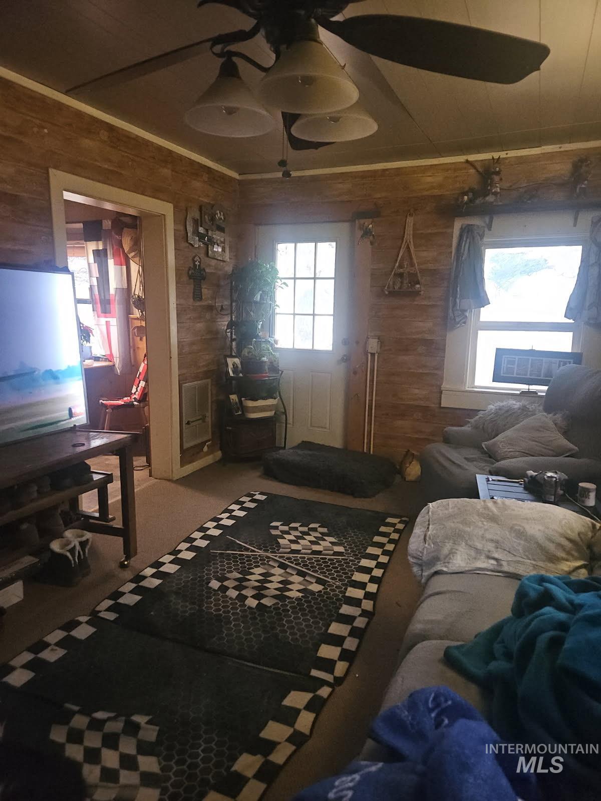 798 High Valley Road Cascade, ID 83611 - Photo 45 of 49 Carpeted bedroom with wood walls, a ceiling fan, and a closet