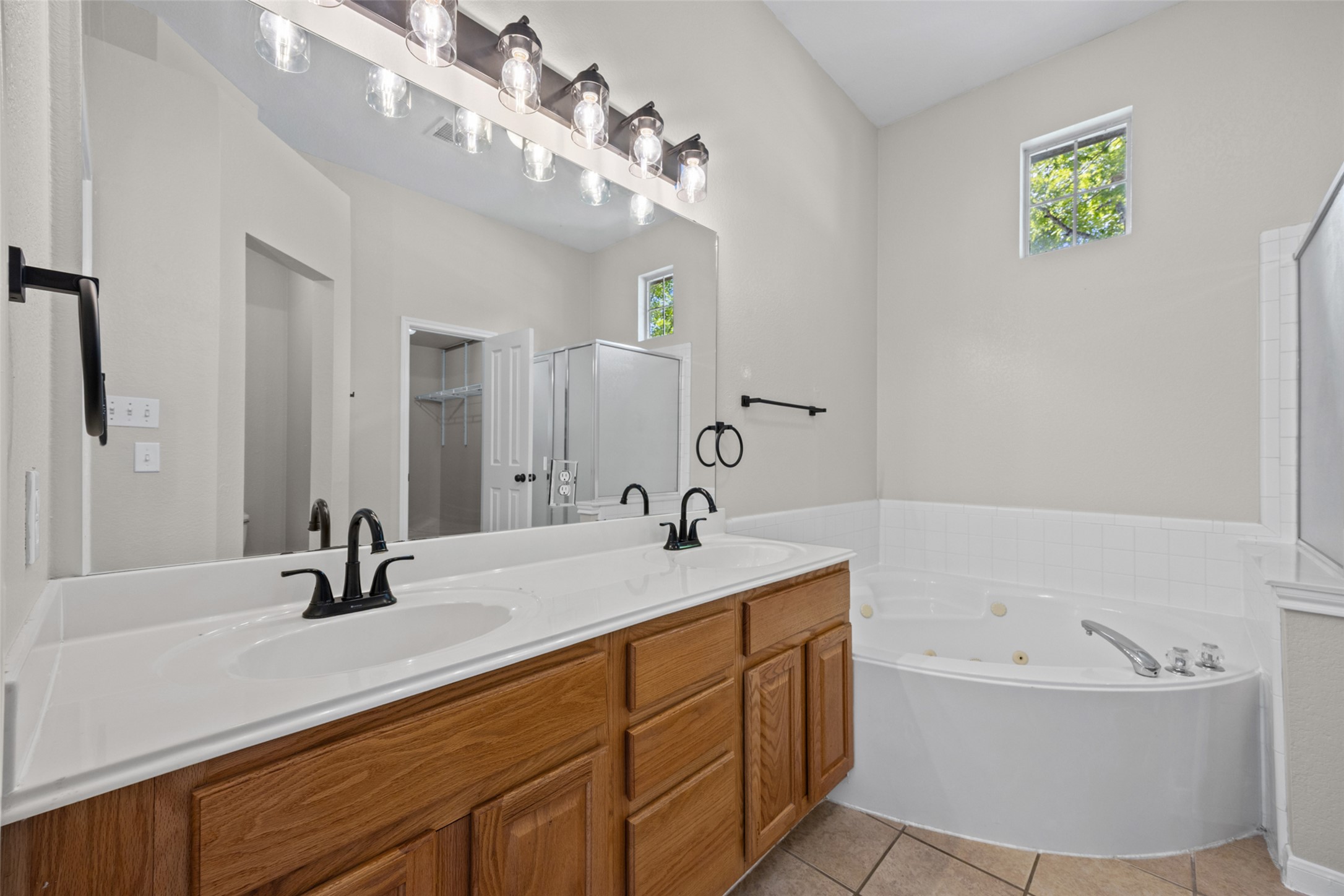 5881 Fergus Kyle, TX 78640 - Photo 20 of 40 A spacious double vanity and a deep soaking jetted tub anchor this relaxed bathroom layout.