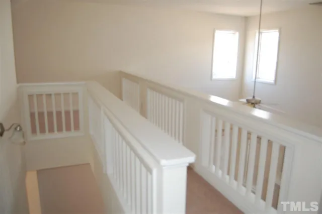 a view of staircase with railing and white walls