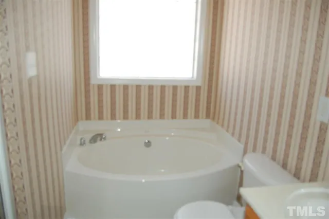a white bath tub sitting next to a white toilet
