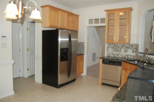 a kitchen with stainless steel appliances granite countertop a refrigerator and a stove