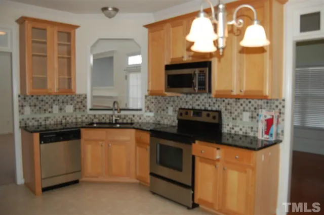 a kitchen with stainless steel appliances granite countertop a stove a sink and a microwave
