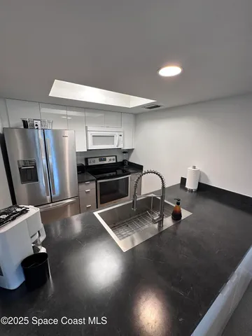 a kitchen with a sink appliances and cabinets