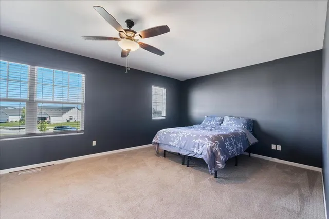 a bedroom with a bed chandelier and a window