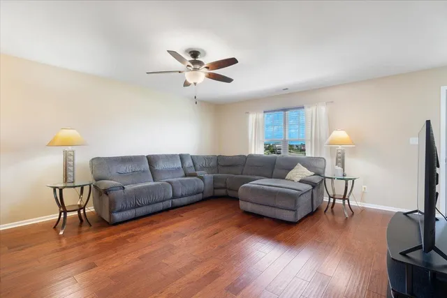 a living room with furniture and a wooden floor