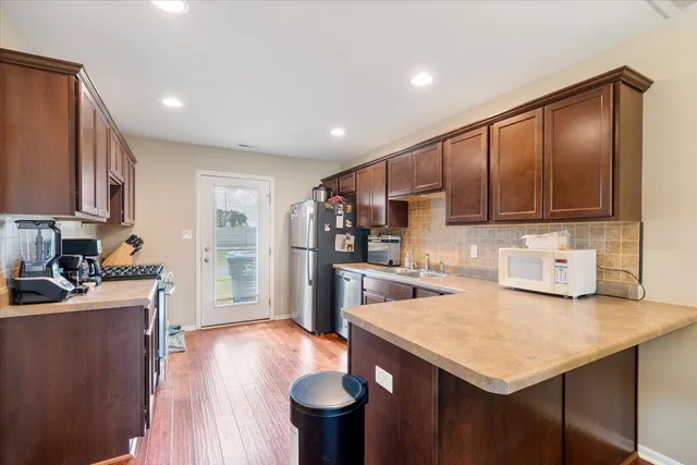 a kitchen with a sink a stove cabinets and wooden floor